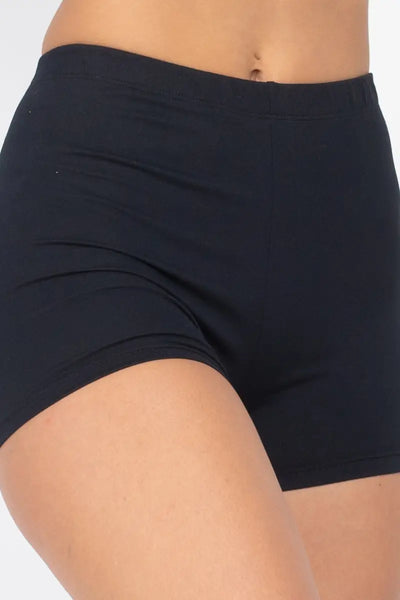 A model wearing black soft and stretchy brushed fiber knit high-waisted shorts with an elastic waistband. Shown in close up