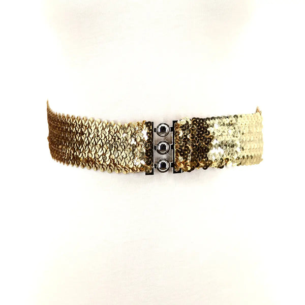 A sparkly gold sequin waist belt with a three pronged silver metal closure in the middle