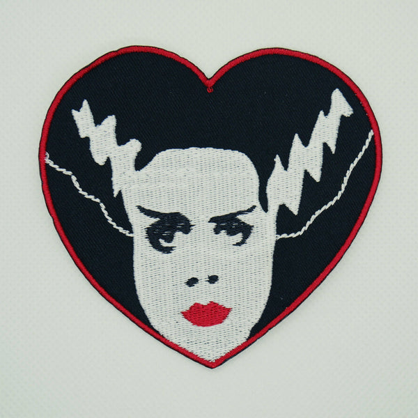 Elsa Lanchester’s iconic Bride of Frankenstein character on a red bordered heart-shaped embroidered patch