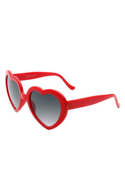 Red plastic frame heart-shaped sunglasses with gradient smoke lenses, shown 3/4 view