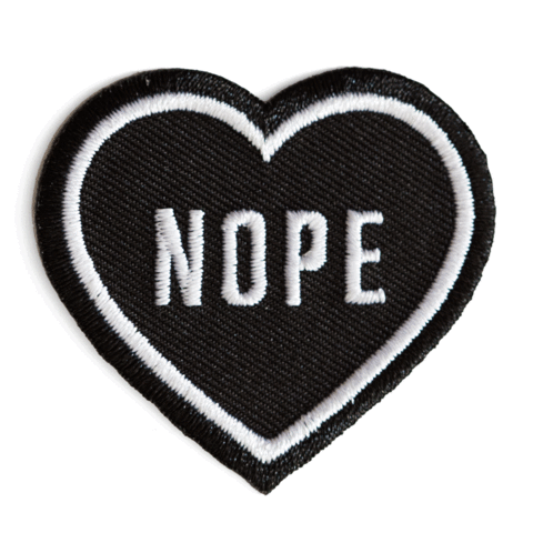 "NOPE" text in white on black heart embroidered patch