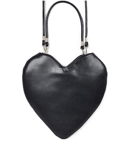 A black faux leather purse in the shape of a heart with a matching hand strap and removable crossbody strap