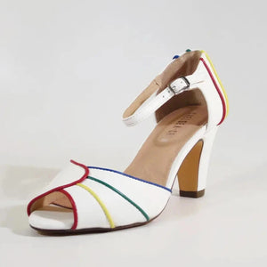 A white pair of peep toe heels with red, yellow, green, and blue piping around the edges of the shoe and back of heel. It has a silver metal buckle on the strap. A single shoe is shown