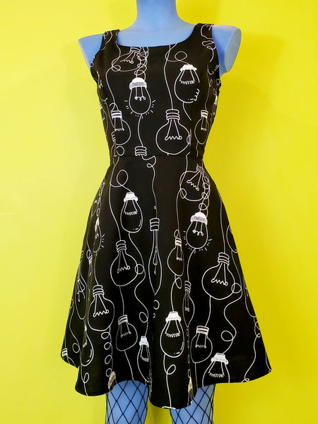 black cotton fit & flare sleeveless mini dress with white allover novelty print of assorted Edison style lightbulbs, shown on blue mannequin