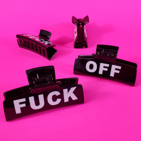 different views of a black plastic claw style hair clip with printed white “FUCK” on one side and “OFF” on the other side