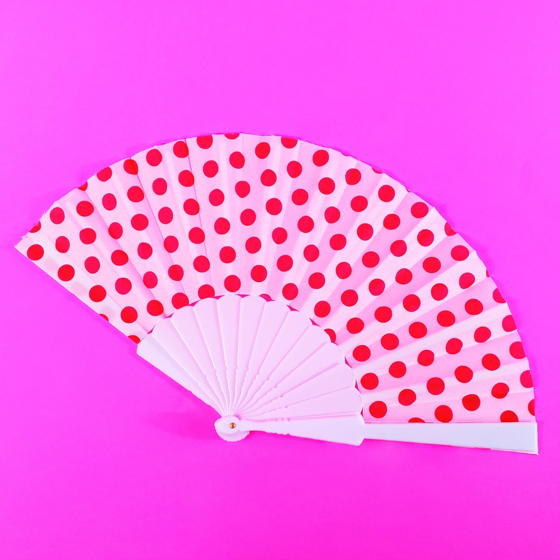 white with red polka dot print fabric folding fan with white plastic ribs
