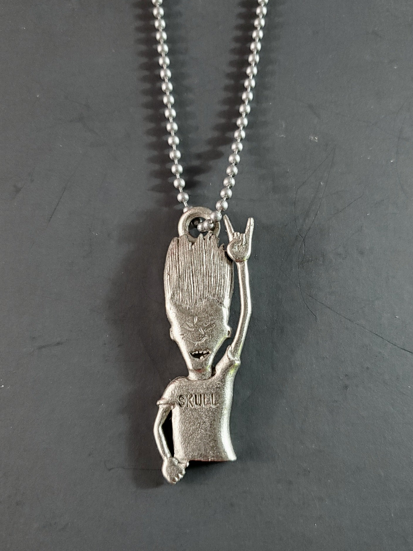 Beavis and Butt-Head deadstock necklace featuring pewter pendant of Butt-Head headbanging strung on 29" ballchain.