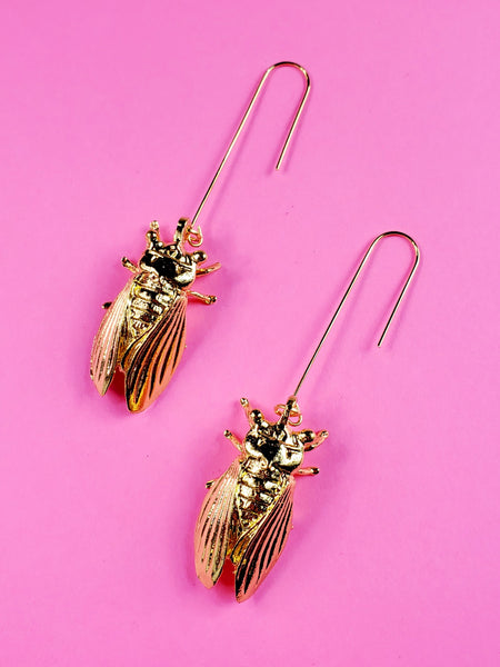 pair of shiny gold metal cicada shaped earrings on long gold wire hooks
