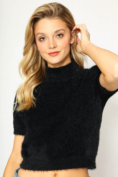 Slightly cropped length short sleeve mock turtleneck "Sweater Girl" style in black, shown on model