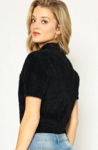 Slightly cropped length short sleeve mock turtleneck "Sweater Girl" style in black, shown back view on model