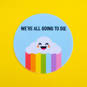 A round vinyl sticker with a light blue background and a smiling cartoon cloud with a rainbow underneath. The words “We’re all going to die” are written in black above the cloud 