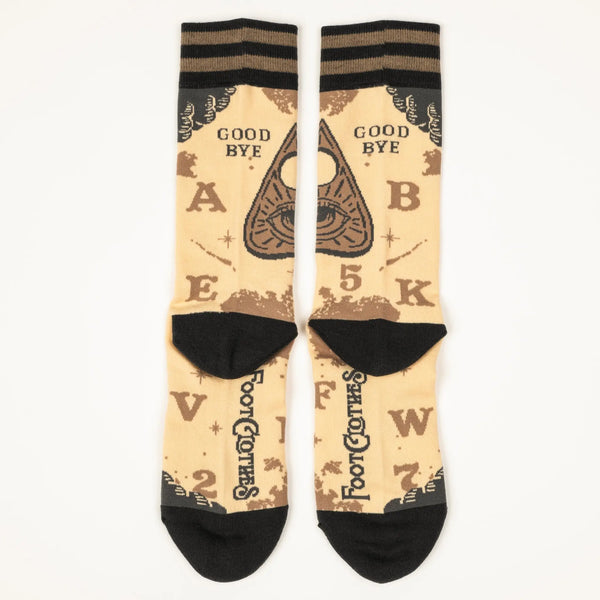 A pair of unisex crew socks with a spirit board design. Each pair has a beige background with dark brown heels and toes & a striped cuff of two shades of brown. Each sock has corresponding designs that when put together resemble the full markings of a spirit board including planchette. This shows the back view of each sock 