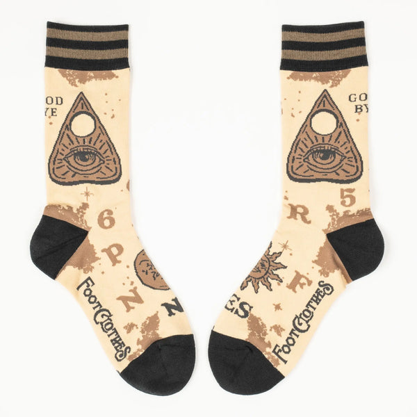 A pair of unisex crew socks with a spirit board design. Each pair has a beige background with dark brown heels and toes & a striped cuff of two shades of brown. Each sock has corresponding designs that when put together resemble the full markings of a spirit board including planchette. This shows the side view of each sock 