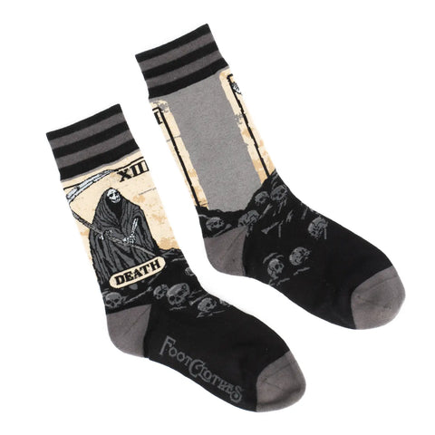 Death tarot card soft stretch cotton blend crew socks, made by FootClothes. Each sock features a take on the classic Rider Waite Tarot illustration in shades of brown, black, and grey on the outward facing side of each sock. The inner side of each sock shows the border of each tarot card with a grey background and the cuffs and are black and grey striped.