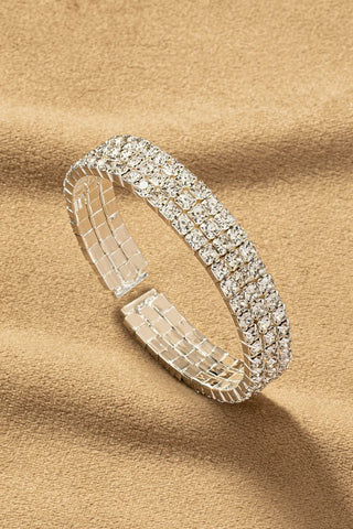 flexible bracelet featuring three rows of sparkly clear square cut "rhinestone" jewels set in shiny silver metal