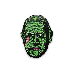 Black enameled mummy pin with neon green and pink detail