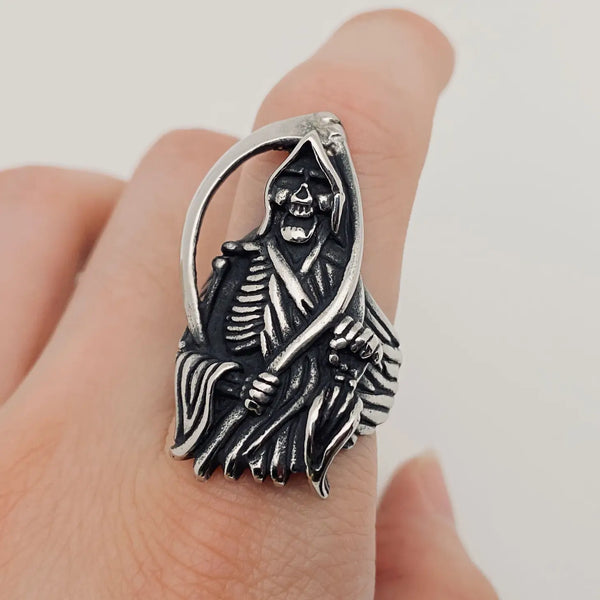 stainless steel ring depicting the grim reaper with his scythe, shown on a finger