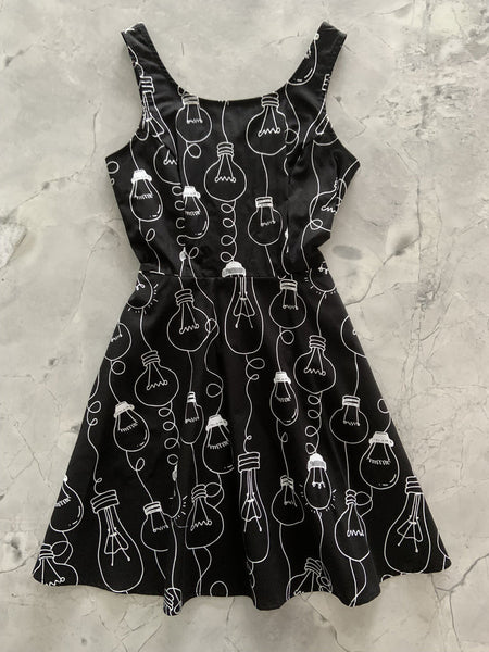 black cotton fit & flare sleeveless mini dress with white allover novelty print of assorted Edison style lightbulbs, shown flatlay