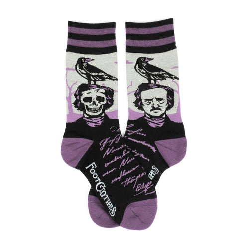 A pair of purple, grey, and black crew socks with black and purple stripes at the cuff and purple toe cap. Each sock has an image of Edgar Allen Poe as a bust style statue, with one as a skeleton version. There is a black Raven sitting on top of each head. The top of the foot has an excerpt of Poe’s writing