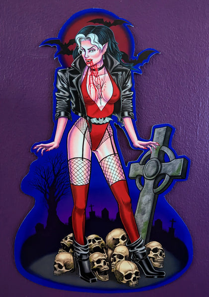 A die cut paper wall decoration of a stylized fierce vampire woman wearing fishnets and a red bodysuit with matching set of boots
