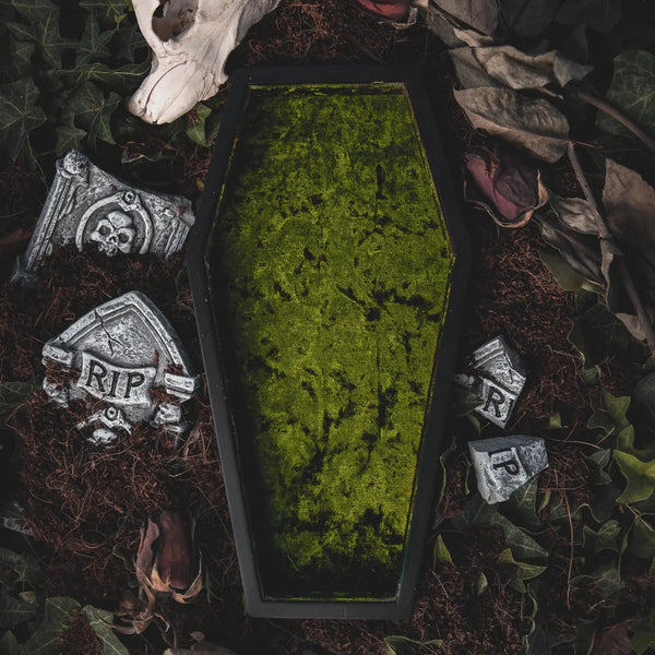 A shallow tray in the shape of a coffin lined with acid green crushed velvet 