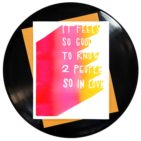 The Zombies “Friends Of Mine”  song inspired greeting card with the caption “It feels so good to know 2 people so in love” in white capital letters against a ombré background of red, pink, and yellow