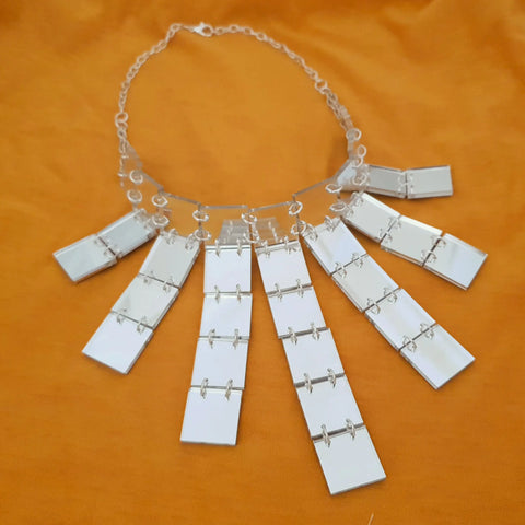 A choker necklace made of Laser-cut square pieces of mirrored silver acrylic hand linked and attached to a chain
