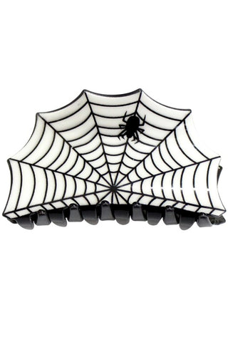 A plastic claw hair clip in the shape of a black and white spiderweb with a small black spider crawling across