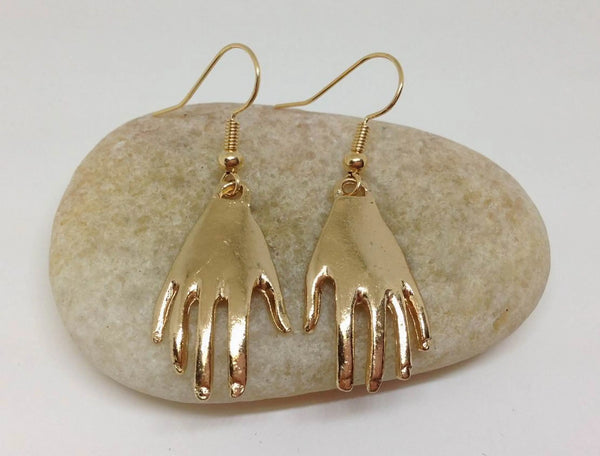 A pair of gold metal hand dangle earrings