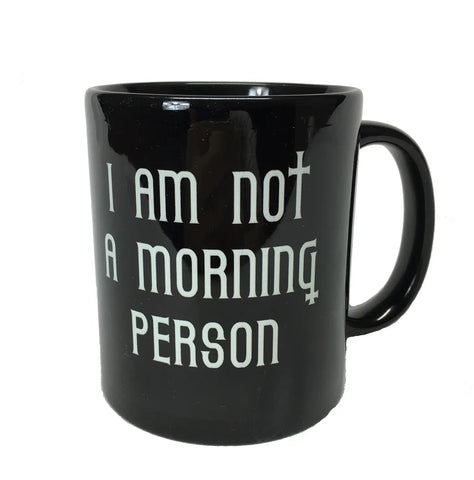 A black ceramic mug with the words “I Am Not A Morning Person” in a Gothic font