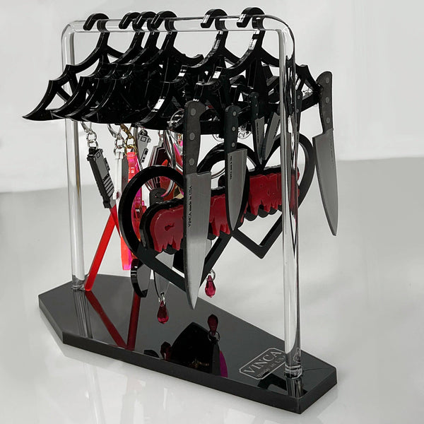 acrylic "Hang in There!" dresser top earring holder stand with eight shiny black laser cut bat-shaped hangers and coffin shaped base, shown with example earrings on display