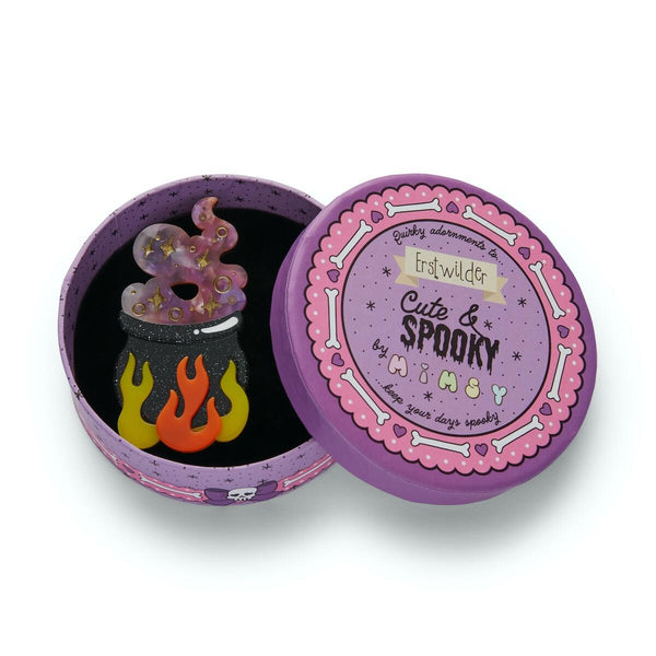 "Cauldron Chitter Chatter" witch's brew in a glitter-y black cauldron over flames layered resin brooch, shown in illustrated round box packaging