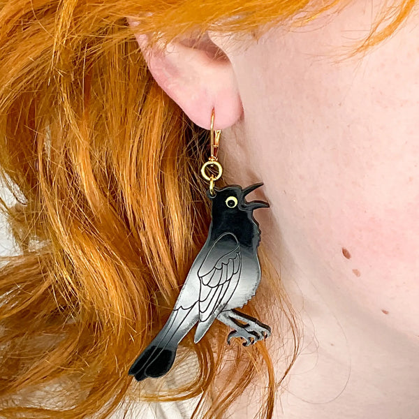 A close up of a model wearing the earrings for scale