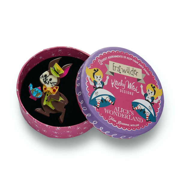 The March Hare holding teapot wearing green vest and hat layered resin brooch, shown in illustrated round box packaging