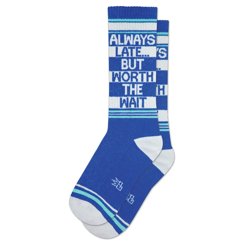 A pair of unisex ribbed crew socks with a royal blue background and white and aqua stripes with the message “ Always Late… But Worth The Wait”