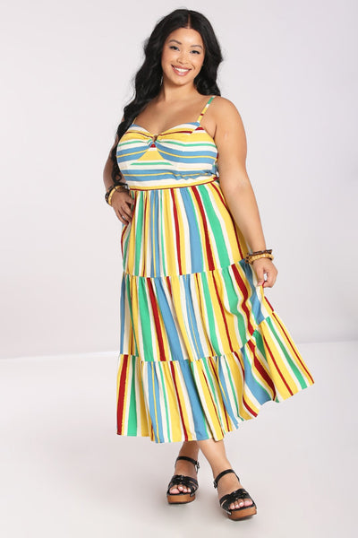 A plus size model wearing a sleeveless sundress with horizontal red, blue, yellow, white, and seafoam stripes. It has adjustable spaghetti straps, a sweetheart neckline, bamboo ring detail at the bodice, and a three tiered long skirt. 