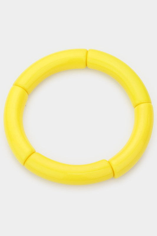 A bright yellow and chartreuse bangle made of segments of resin strung on elastic cord