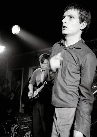 Black and white photograph of Ian Curtis pictured onstage with Joy Division in 1979
