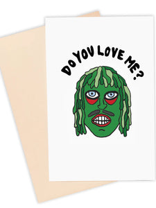 A note card featuring the face of Old Gregg from The Mighty Boosh with the caption “DO YOU LOVE ME?” above his head in black bubble lettering 
