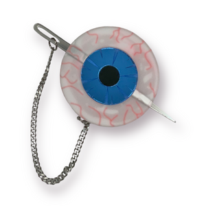 An acrylic brooch in the shape of a bloodshot eye with bright blue mirrored iris and a shiny mirrored sewing needle attached with a curb style chain that can be placed through the eyeball