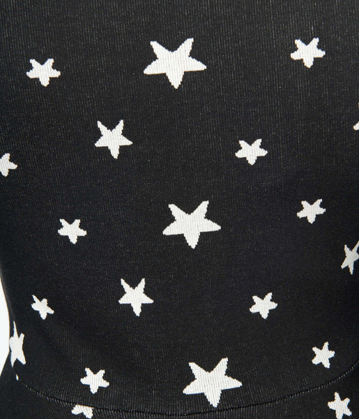 A black sweater knit fit and flare dress with raglan bell sleeves in a black and white star pattern. Detail shot to show knit fabric and pattern