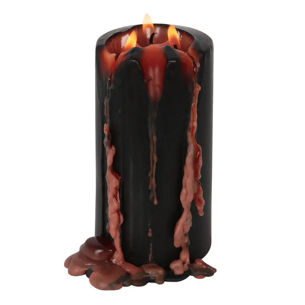 A large black pillar candle that drips bloody red when lit. Shown lit with red wax dripping down its side