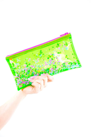A rectangular pouch made of neon green vinyl with a pink plastic zipper. The sides of the pouch have pockets of liquid glitter filled with multicolored star-shaped glitter 
