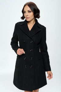 double breasted faux wool coat in black with large patch pockets with flaps, button details at cuffs, and flattering darting throughout. Shown on model