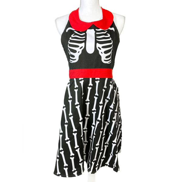 Retro-style full coverage bib front apron in a skeleton rib cage and striped bone print finished with red waistband tieback closure and peter pan collar.