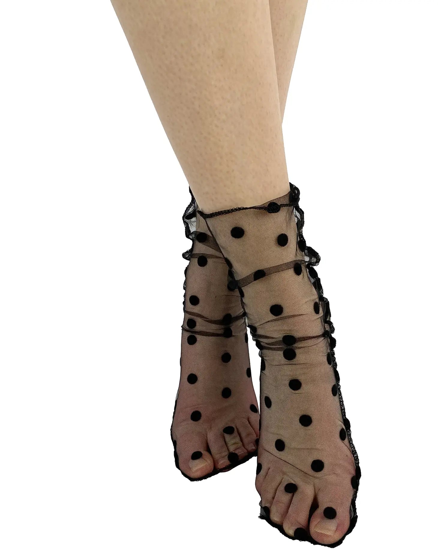 Black tulle slouchy ankle socks with a classic black flocked dot pattern. Shown on a model without shoes