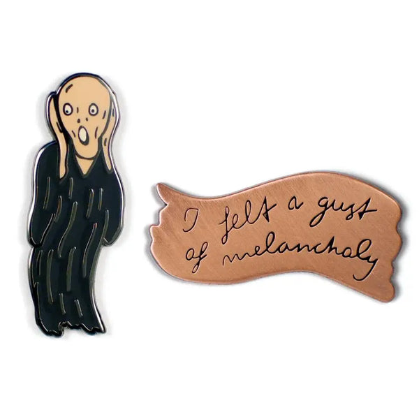 A set of two lapel pins, one is an enamel pin of Edvard Munch’s Scream painting and the other is a brass pin with a diary excerpt embossed onto it