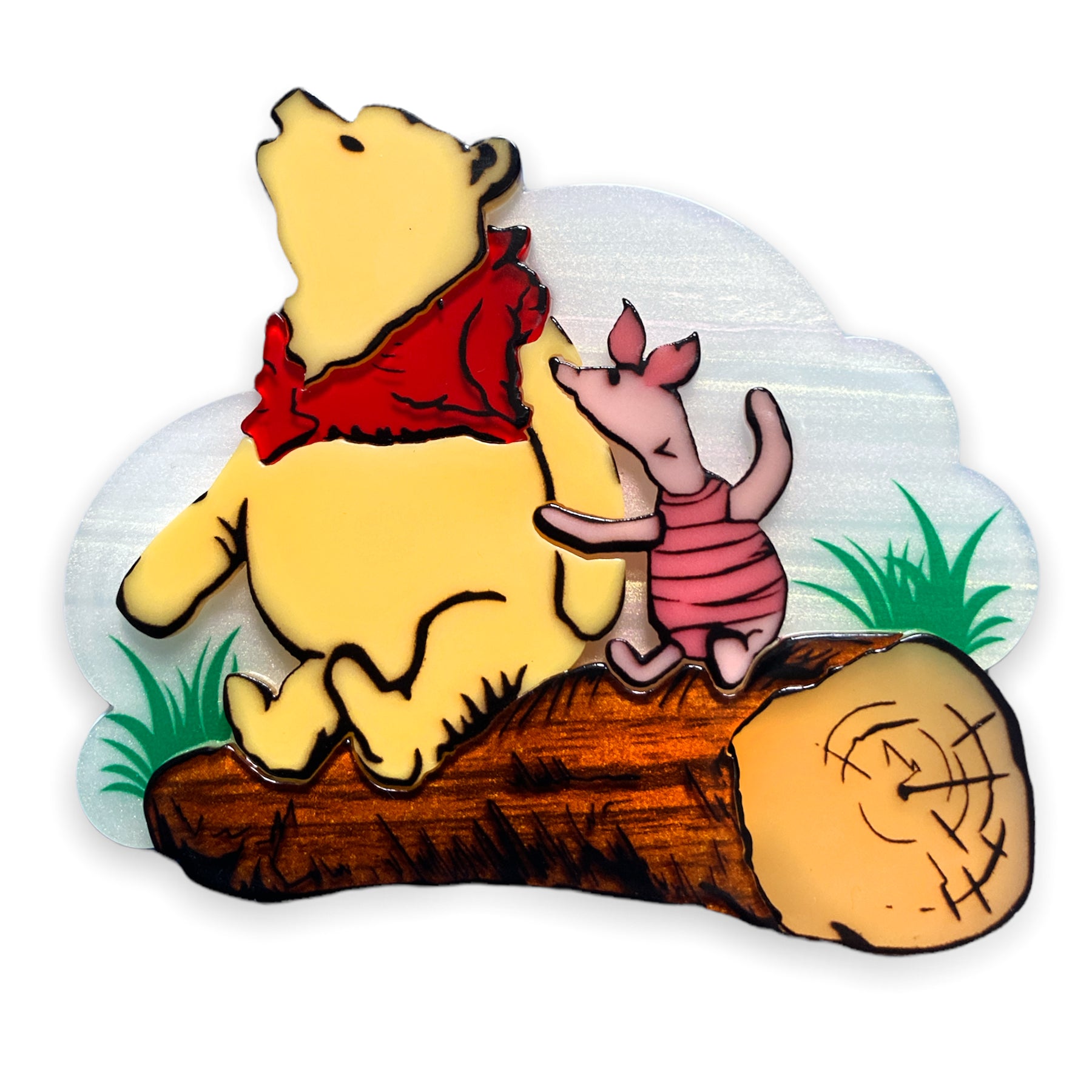 a layered acrylic resin brooch with painted detail showing Winnie the Pooh and Piglet sitting on a log in front of a cloud