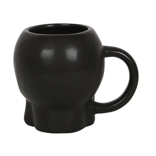 A black satin finish ceramic mug in the detailed shape of a skull. Shown from behind 