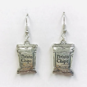 A pair of silver metal dangle earrings in the shape of two bags of potato chips with the label “Potato Chips”. With fishhook hardware